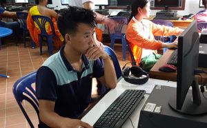 Students complete computer exam in Laos school